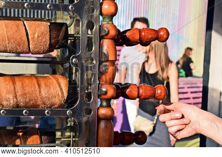 The Process Of Baking Trdelnik. Traditional Czech Sweet Treat Trdelnik. To Prepare On A Special Wood