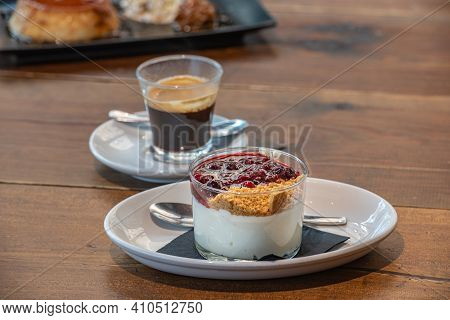Flan Casero And Cheesecake Served In A Glass With A Berry Sauce.