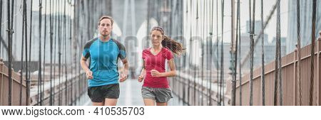 New York city runners athletes training for run marathon on Brooklyn Bridge banner. Fit active interracial couple on outdoor running exercise in raining day. Summer rain. Asian woman, Caucasian man.