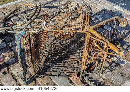 Rusty And Damaged Shopping Cart Found In The Port Of Kiel In Germany