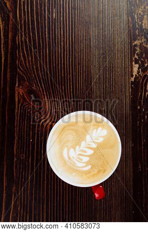 Fresh Brewed Coffee With Latte Art In Red Cup On A Wooden Table. Copy Space. Flat Lay