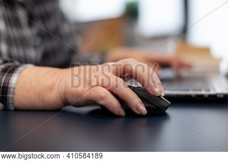 Close Up Of Old Entrepreneur Lady Using Mouse In Home Office. Elderly Woman In Home Living Room Usin