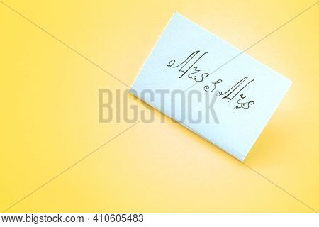 White Paper Card With The Inscription Mrs And Mrs On Yellow Background. Lesbian Wedding