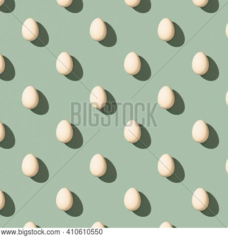 Pattern made of white eggs on pastel green background. Minimal food concept. Flat lay