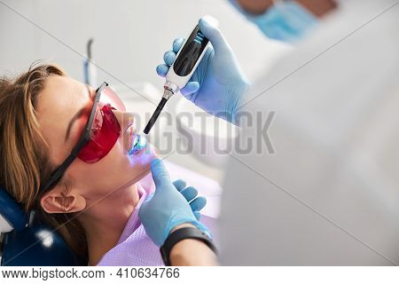 Stomatologist Setting Dental Sealants In Person Teeth