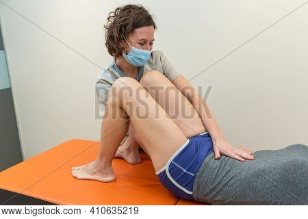 Physiotherapist And Patient In Global Postural Re-education Session, With Pandemic Protection Mask.