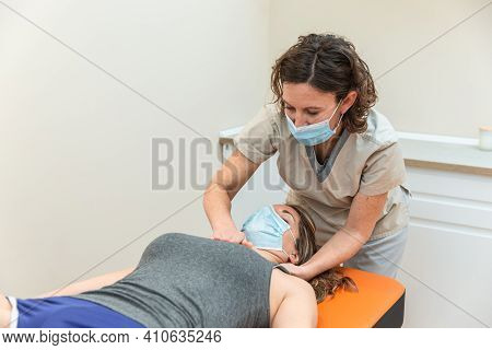 Physiotherapist And Patient In Global Postural Re-education Session, With Pandemic Protection Mask.