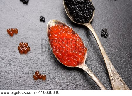 Black Caviar Of Paddlefish Fish And Red Chum Salmon Caviar In A Spoon, Black Background, Top View