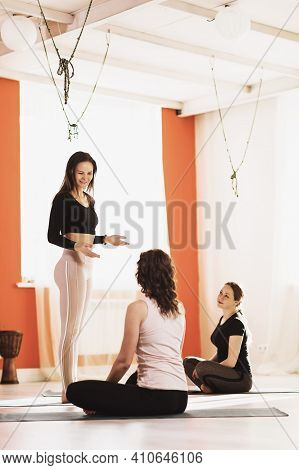 A Woman Teacher Of Universal Yoga, Holds A Consultation Among  Students In The Studio.
