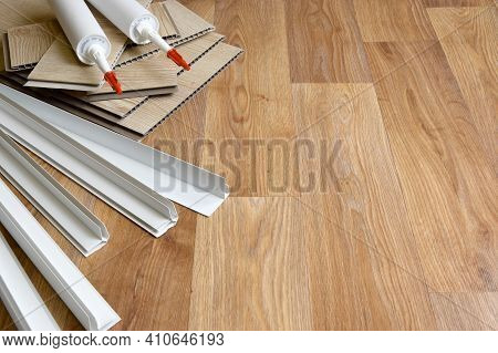 Set Of Items For Pvc Ceiling Indoor Works. Assembly Adhesive Bottles And Pvc Panels With Plastic Cor