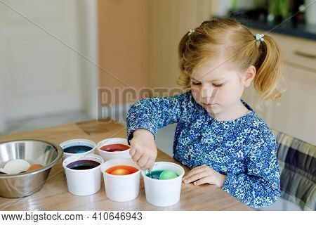 Excited Little Toddler Girl Coloring Eggs For Easter. Cute Happy Child Looking Surprised At Colorful