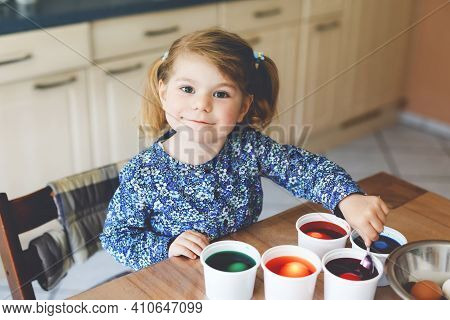 Excited Little Toddler Girl Coloring Eggs For Easter. Cute Happy Child Looking Surprised At Colorful