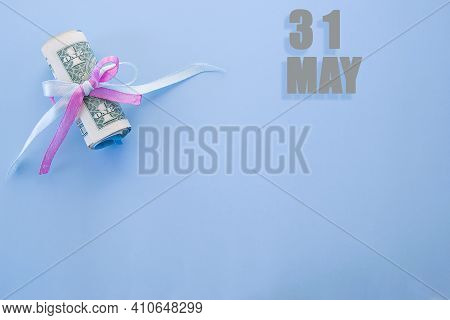 Calendar Date On Blue Background With Rolled Up Dollar Bills Pinned By Blue And Pink Ribbon With Cop