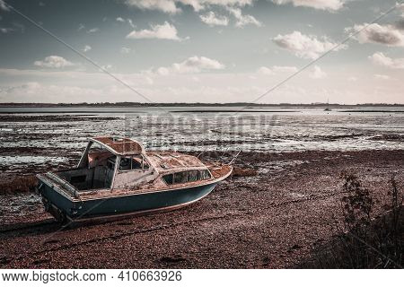 Old Boat On The Beach. Isolated Boat On A Shingle Beach During Mid Day Winter Sun While Tide Was Out