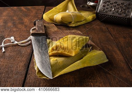Pamonha, Brazilian Corn Food, Called Pamonha. On A Rustic Table With Knife And Old Corn Grater, Low