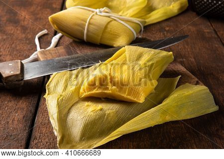 Pamonha, Brazilian Corn Food, Called Pamonha. On A Rustic Table With Knife And Old Corn Grater, Low
