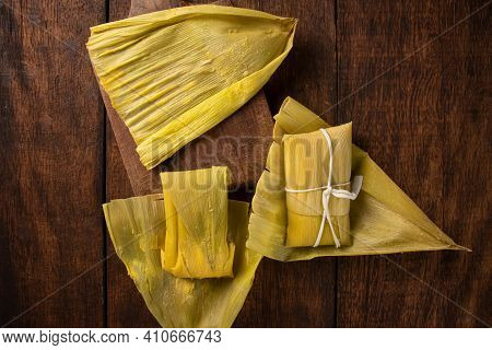 Pamonha, Brazilian Corn Food, Called Pamonha. On A Rustic Table With Knife, Low Key Portrait, Dark A
