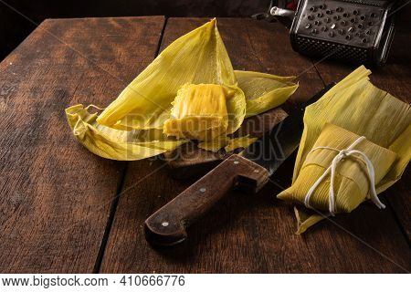 Pamonha, Brazilian Corn Food, Called Pamonha. On A Rustic Table With Knife And Old Corn Grater, Low