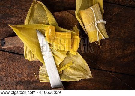 Pamonha, Brazilian Corn Food, Called Pamonha. On A Rustic Table With Knife, Low Key Portrait, Dark A