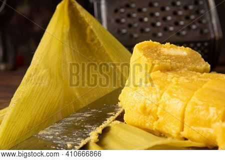 Pamonha, Brazilian Corn Food, Called Pamonha. On A Rustic Table With Knife And Old Corn Grater, Low
