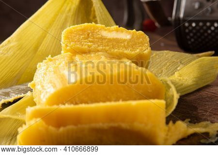 Pamonha, Brazilian Corn Food, Called Pamonha. On A Rustic Table With Knife And Old Corn Grater, Low