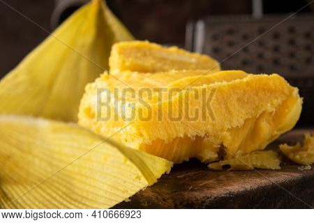 Pamonha, Brazilian Corn Food, Called Pamonha. On A Rustic Table With Knife And Old Corn Grater, Low