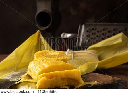 Pamonha, Brazilian Corn Food, Called Pamonha. On A Rustic Table With Knife And Old Corn Grater, Low
