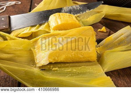 Pamonha, Brazilian Corn Food, Called Pamonha. On A Rustic Table With Knife And Old Corn Grater, Low