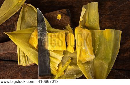 Pamonha, Brazilian Corn Food, Called Pamonha. On A Rustic Table With Knife, Low Key Portrait, Dark A