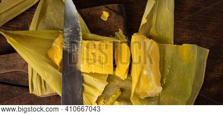 Pamonha, Brazilian Corn Food, Called Pamonha. On A Rustic Table With Knife, Low Key Portrait, Dark A