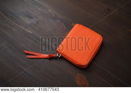 Orange Pocket Purse Bag On Wood Table Background. Small Fabric Cosmetic Bag Or Wallet Bag.