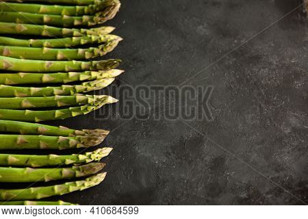 Bunch Of Asparagus Arranged In A Row On Dark Grey And White Background With Copy Space. Green Aspara