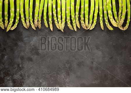 Bunch Of Asparagus Arranged In A Row On Dark Grey And White Background With Copy Space. Green Aspara