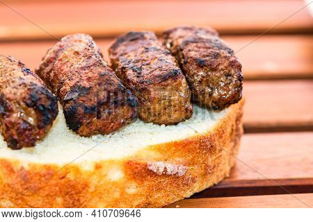 Meat Rolls Called Mici Or Mititei On A Slice Of Bread Isolated