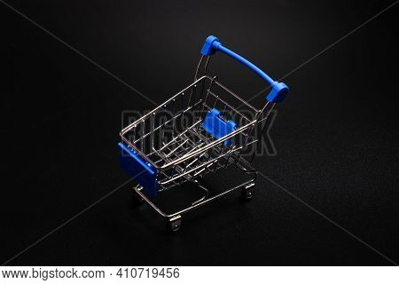 Small Blue Shopping Cart On A Black Background. Copspace