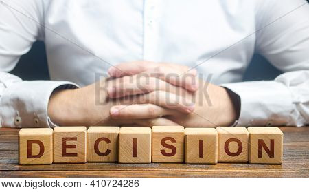 Man Folded His Hands On A Background Of Blocks With The Word Decision. Make The Right Decision, The 