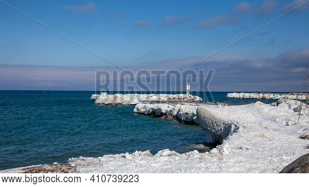 The Frozen Pier At The Entrance Of The Thornbury Yacht Club Marina In The Winter. Large Ice Sickles 