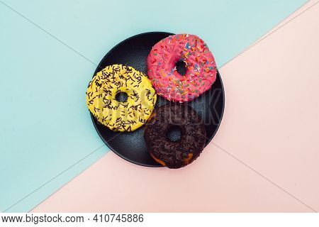 Colored Donuts With Colorful Sprinkles On Pink And Blue Background. National Pink Day Or Doughnut Da