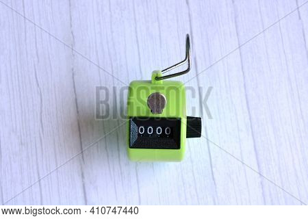 4 Digits Green Tally Counter Or Hand Counter On The Wooden Background