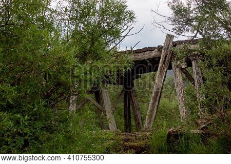 Old Destroyed Wooden Bridge On A Rainy Day. Mysterious Landscape. The Nature Of Russia In The Summer