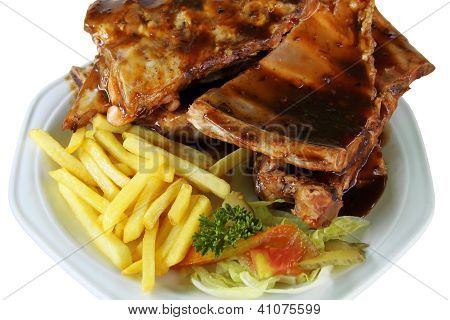 Rippchen und Pommes auf dem weiÃŸen Teller hautnah