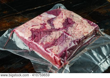 Cryovac Packed Meat Beef Brisket In Vacuum Set, On Old Dark  Wooden Table Background
