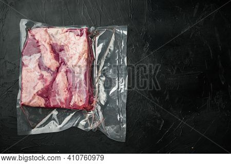 Cryovac Packed Meat Beef Brisket In Vacuum Set, On Black Stone Background, Top View Flat Lay , With 