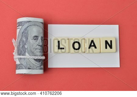 Money Banknote And Square Letters With Text Loan Over Red Background.