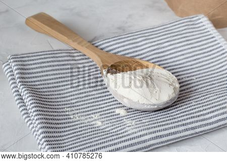 Crumbly Xanthan Gum In A Wooden Spoon.