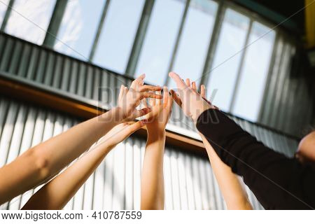 Conceptual Image Of Teamwork And Cooperation With A Group Of People Raising Their Hands And Placing 