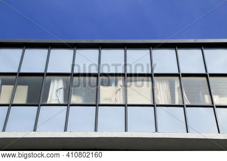 Rectilinear And Geometric Facade With Glass Windows Over Blue Sky