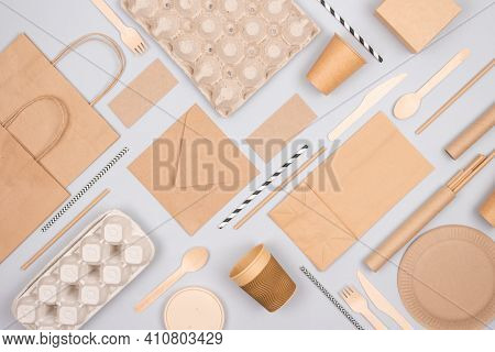 Flat Lay Composition With Eco-friendly Tableware And Kraft Paper Food Packaging On Gray Background. 