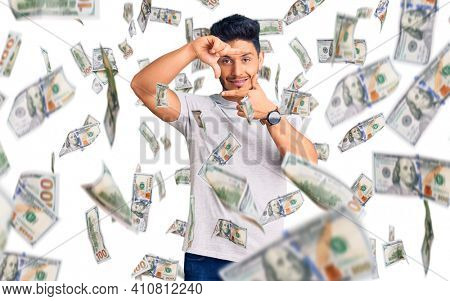 Handsome latin american young man wearing casual tshirt smiling making frame with hands and fingers with happy face. creativity and photography concept.