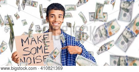 Young african amercian man holding make some noise banner pointing finger to one self smiling happy and proud